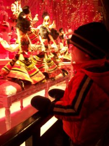 Child looking at Parisian window display at Christmastime